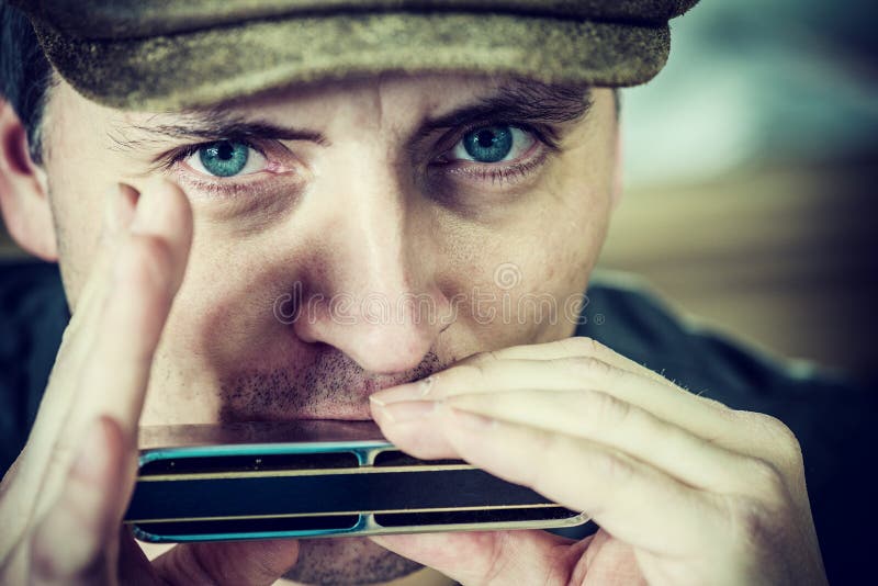 Close up portrait of a man playing a harmonica