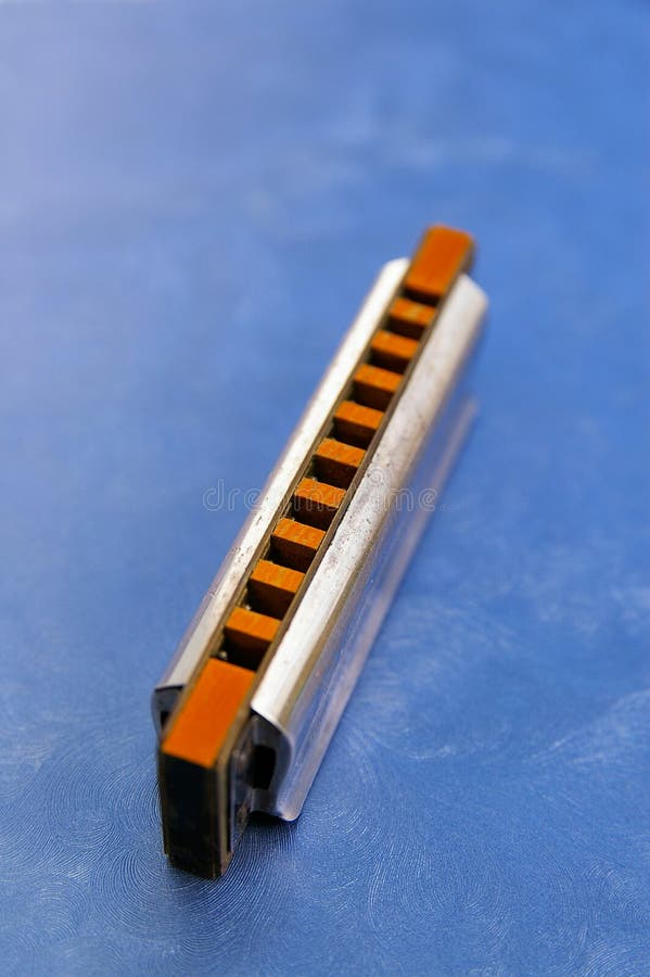 Closeup of a harmonica on blue background. Closeup of a harmonica on blue background