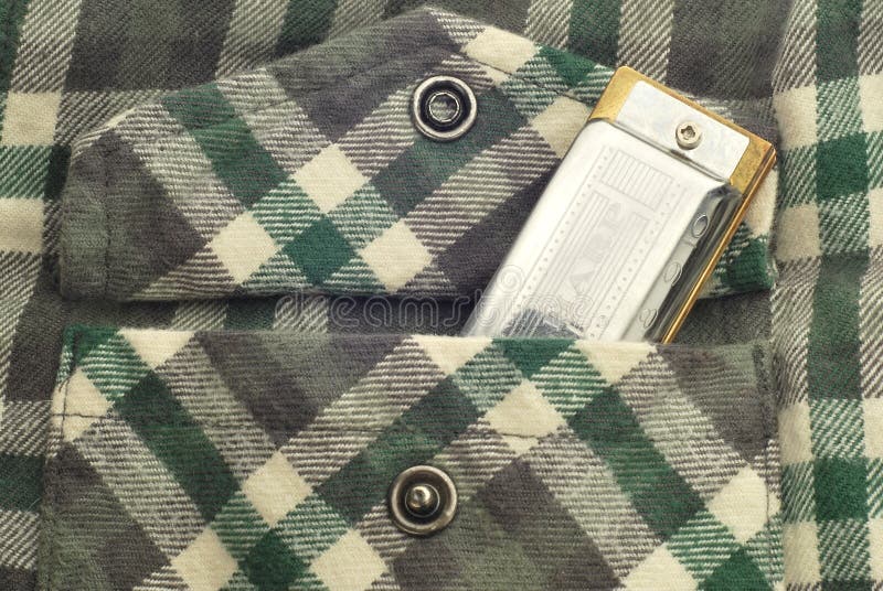 Harmonica/blues harp in plaid shirt pocket. Harmonica/blues harp in plaid shirt pocket