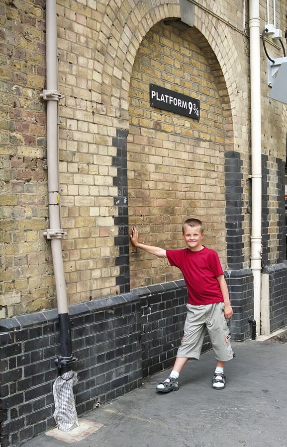 Boy leaning against the wall to fantasy Platform 9 3/4 from famous Harry Potter book. Boy leaning against the wall to fantasy Platform 9 3/4 from famous Harry Potter book.