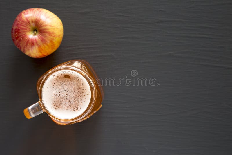 Hart Apfelweinale in einem Glasgefäßbecher auf einer schwarzen Oberflächendraufsicht. flache Lage von oben. Raum für Text stockfotografie