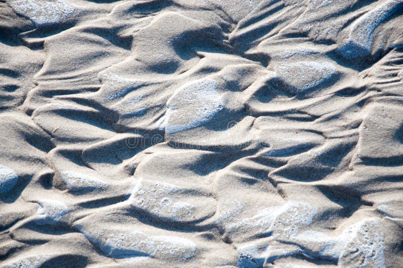 Natural heart shapes in wet sand closeup. Natural heart shapes in wet sand closeup.