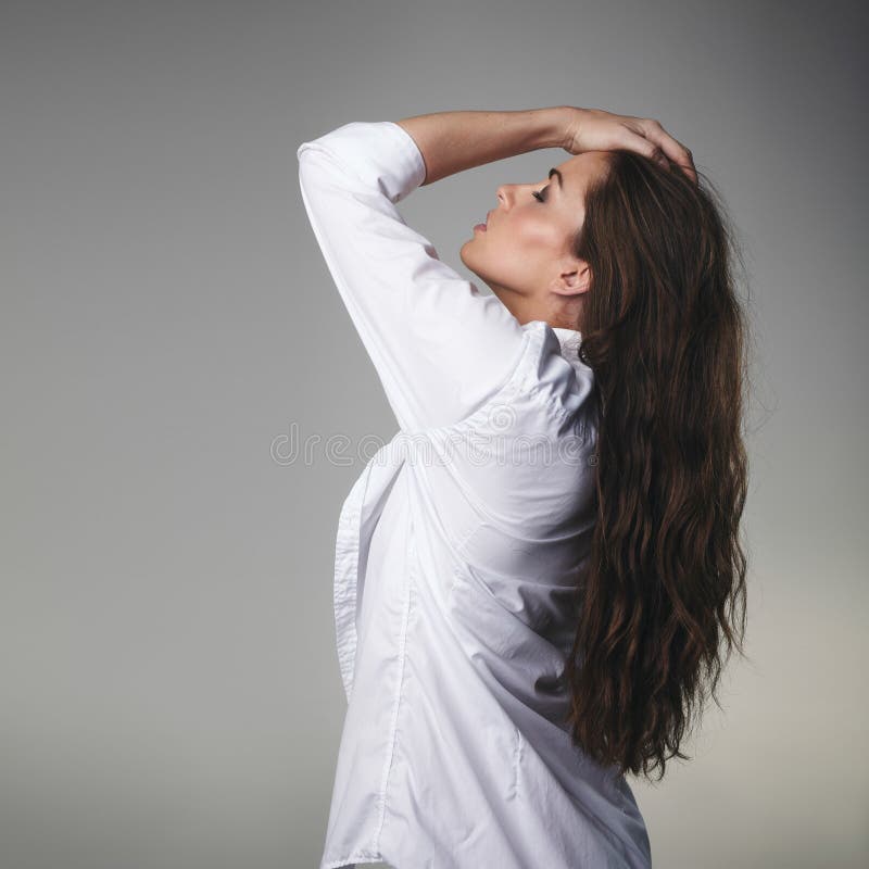 Hartstochtelijk jong brunette op grijze achtergrond stock afbeelding Hartstochtelijk jong brunette op grijze achtergrond stock afbeelding