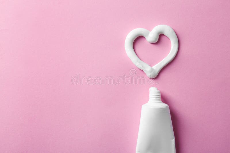 Hartvorm van tandpasta dichtbij buis wordt gemaakt en ruimte voor tekst op kleurenachtergrond die stock foto Hartvorm van tandpasta dichtbij buis wordt gemaakt en ruimte voor tekst op kleurenachtergrond die stock foto