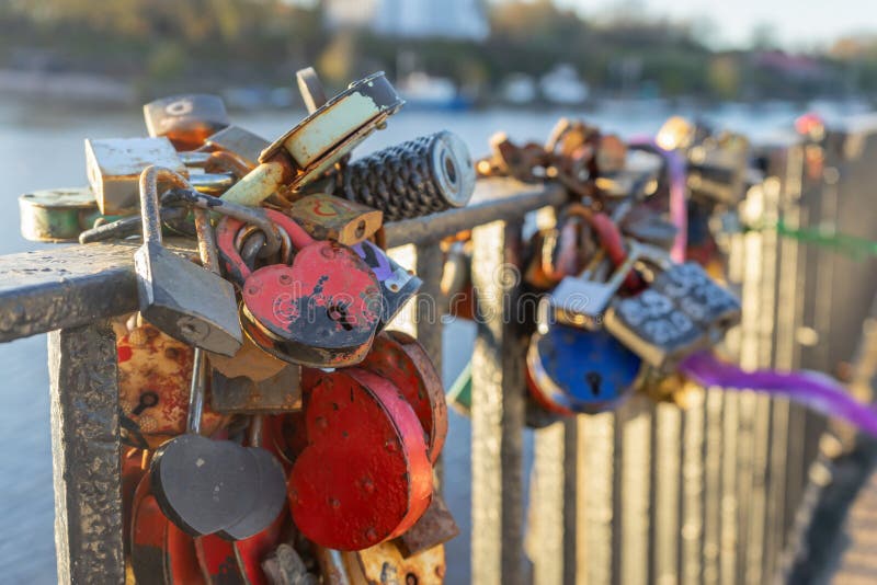 Heart-shaped locks on the railing of the bridge. A symbol of eternal love on the wedding day. A romantic tradition. Heart-shaped locks on the railing of the bridge. A symbol of eternal love on the wedding day. A romantic tradition.