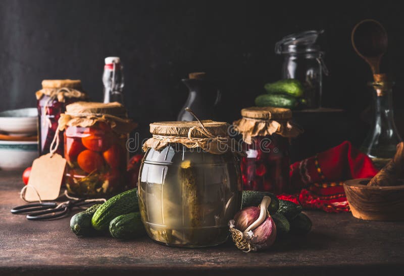 Harvest preserve concept. Glass jars with fermented, pickled and canned vegetables and fruits on dark rustic kitchen table. stock image Harvest preserve concept. Glass jars with fermented, pickled and canned vegetables and fruits on dark rustic kitchen table. stock image