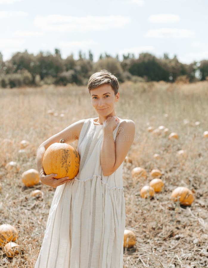 harvesting yellow pumpkins on a plantation woman in the countryside, agriculture, farmland, gourd, seed, organic, soil, season, natural, holiday, october, decoration, garden, healthy, vegetarian, outdoor, field, november, color, fruit, growth, art, festival, graphic, thanksgiving, background, autumn, crop, food, rural, halloween, squash, orange, vegetable, industry, grain. harvesting yellow pumpkins on a plantation woman in the countryside, agriculture, farmland, gourd, seed, organic, soil, season, natural, holiday, october, decoration, garden, healthy, vegetarian, outdoor, field, november, color, fruit, growth, art, festival, graphic, thanksgiving, background, autumn, crop, food, rural, halloween, squash, orange, vegetable, industry, grain