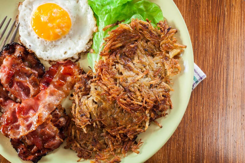 Hash Browns. Potato Pancakes with Crispy Fried Bacon and Fried E Stock