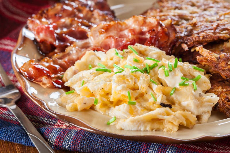 Hash Browns. Potato Pancakes with Crispy Fried Bacon and Scrambled Eggs