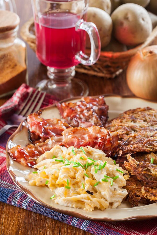 Hash Browns. Potato Pancakes with Crispy Fried Bacon and Scrambled Eggs