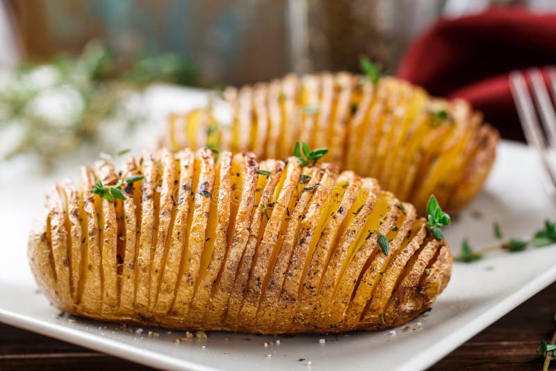 Hasselback potatoes with herbs on a plate. Hasselback potatoes with herbs on a plate