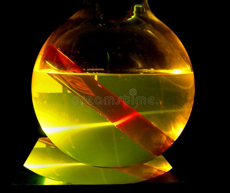 Haste do rubi em uma solução da tintura sob o raio laser fotografia de stock Haste do rubi em uma solução da tintura sob o raio laser fotografia de stock