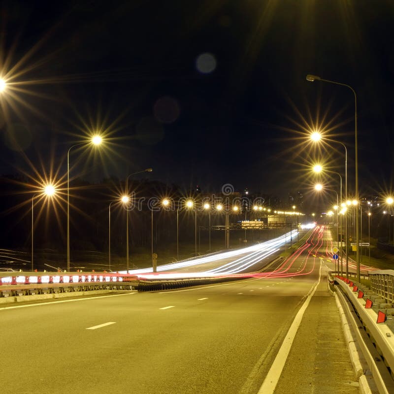 Hastighetstrafik på den dramatiska solnedgången Tid - ljus skuggar på motorwayhuvudvägen på natten, stads- bakgrund för långt exp arkivbilder Hastighetstrafik på den dramatiska solnedgången Tid - ljus skuggar på motorwayhuvudvägen på natten, stads- bakgrund för långt exp arkivbilder