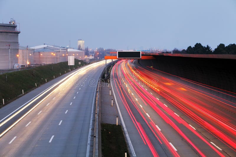Hastighetstrafik på den dramatiska solnedgången Tid - ljus skuggar på motorwa fotografering för bildbyråer Hastighetstrafik på den dramatiska solnedgången Tid - ljus skuggar på motorwa fotografering för bildbyråer
