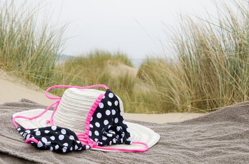 Hat, bikini and shoes on beach towel