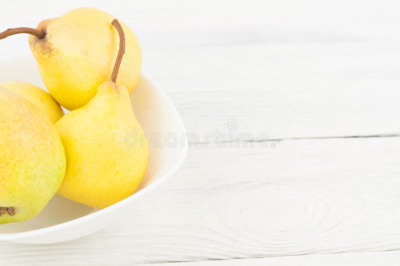 Haufen von frischen reifen gelben ganzen Birnen in der weißen keramischen Schüssel lizenzfreies stockfoto Haufen von frischen reifen gelben ganzen Birnen in der weißen keramischen Schüssel lizenzfreies stockfoto