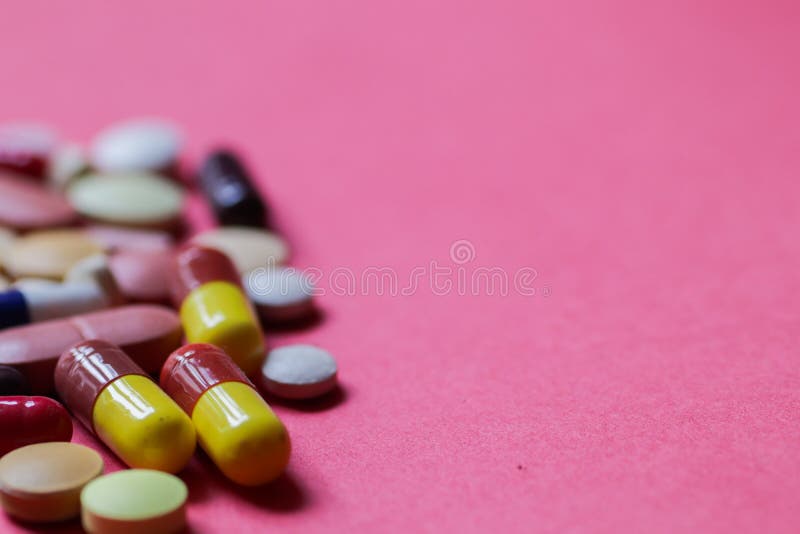 Haufen von Tabletten und von Kapseln im rosa Hintergrund mit Raum für den Text selektiv fokussiert lizenzfreies stockbild Haufen von Tabletten und von Kapseln im rosa Hintergrund mit Raum für den Text selektiv fokussiert lizenzfreies stockbild