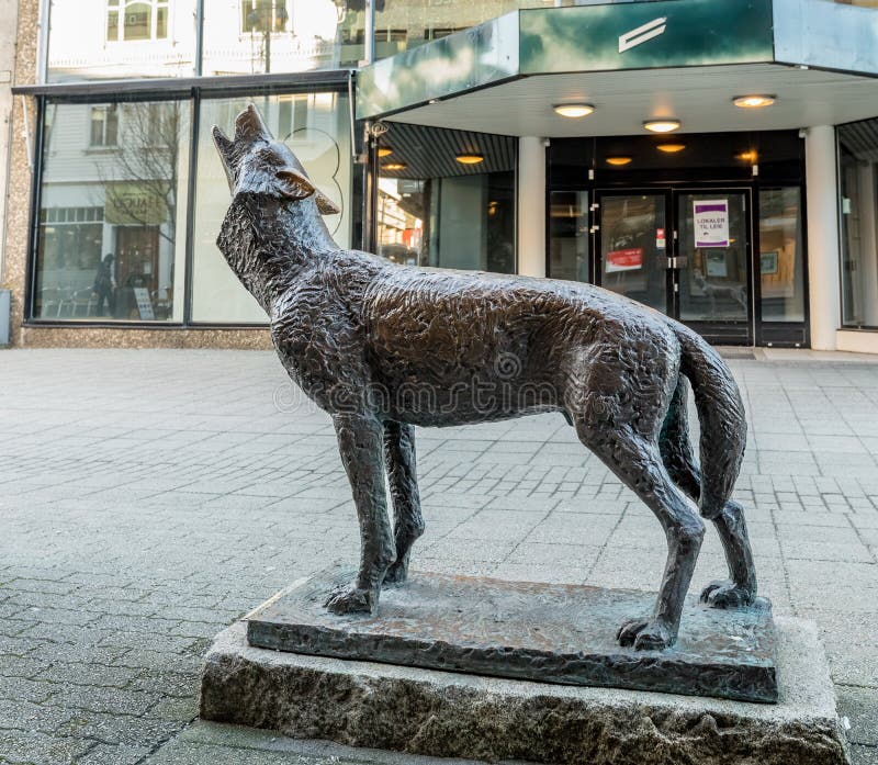 Haugesund, Noorwegen - Januari 9, 2018: Het beeldhouwwerk van een wolf, Canis-wolfszweer, in Haugesund-stadscentrum stock fotografie Haugesund, Noorwegen - Januari 9, 2018: Het beeldhouwwerk van een wolf, Canis-wolfszweer, in Haugesund-stadscentrum stock fotografie