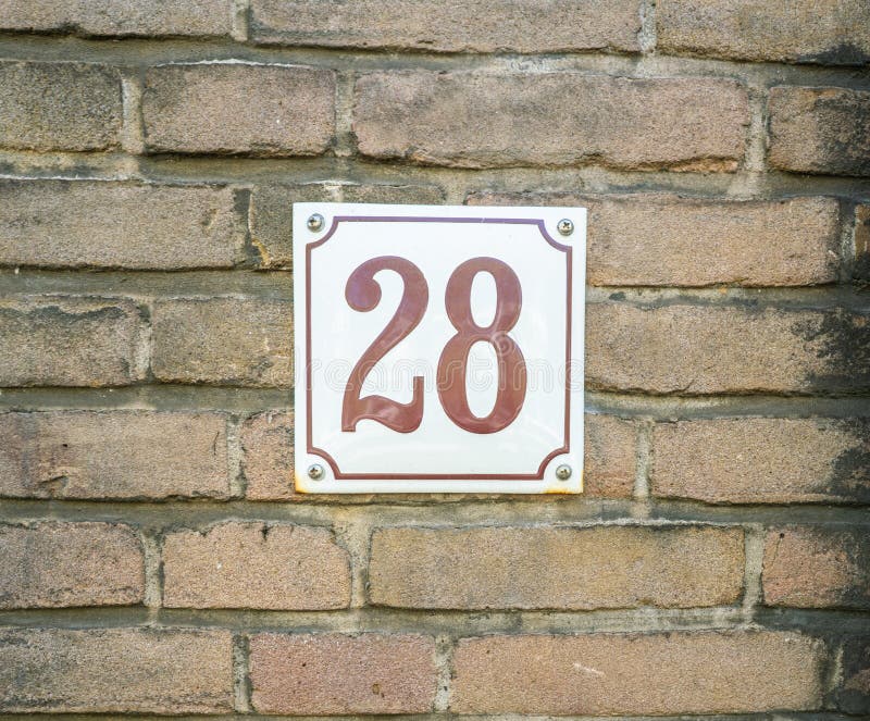 Hausnummer 28 achtundzwanzig braune Zahlen auf einem weißen Plattenbetrug lizenzfreies stockbild Hausnummer 28 achtundzwanzig braune Zahlen auf einem weißen Plattenbetrug lizenzfreies stockbild