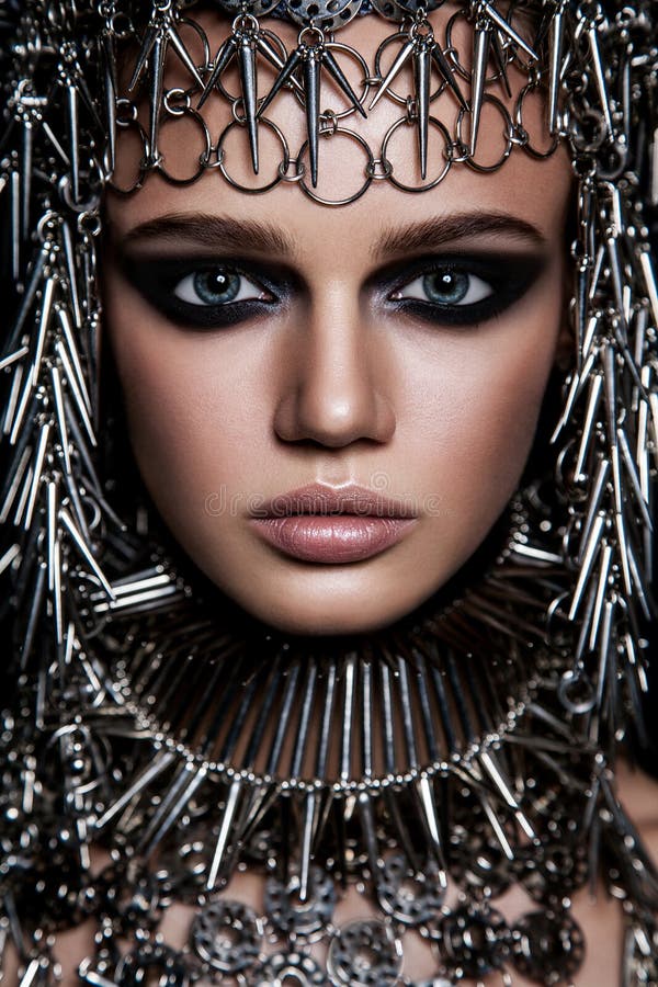 Hautecouture-Schönheitsmodell mit metallischem Headwear und dunkle Make-up und Blaueaugen auf schwarzem Hintergrund lizenzfreie stockfotografie Hautecouture-Schönheitsmodell mit metallischem Headwear und dunkle Make-up und Blaueaugen auf schwarzem Hintergrund lizenzfreie stockfotografie