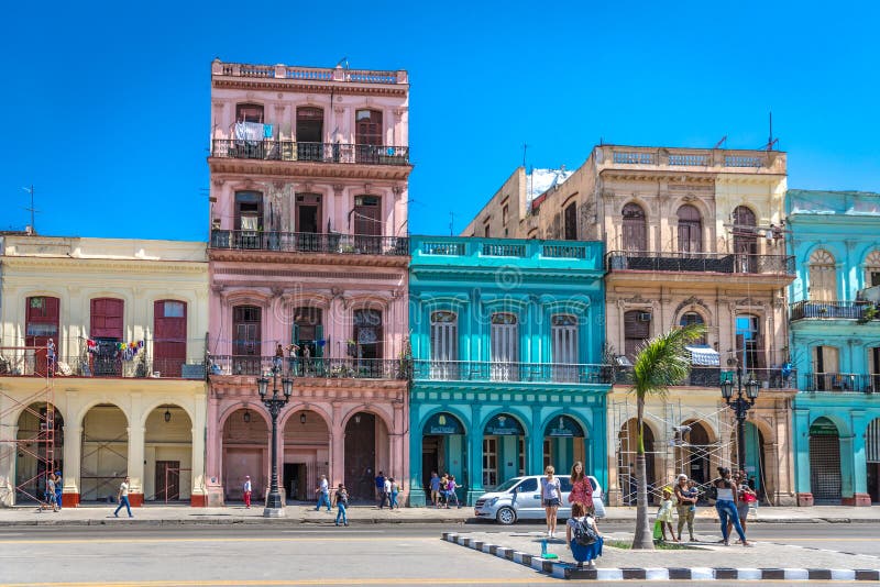 Havannacigarr Kuba - mars 11th 2018 - en färgrik gata mycket av hus, kolonial stil, blå himmel, turister som tar bilder i havanna royaltyfri bild Havannacigarr Kuba - mars 11th 2018 - en färgrik gata mycket av hus, kolonial stil, blå himmel, turister som tar bilder i havanna royaltyfri bild