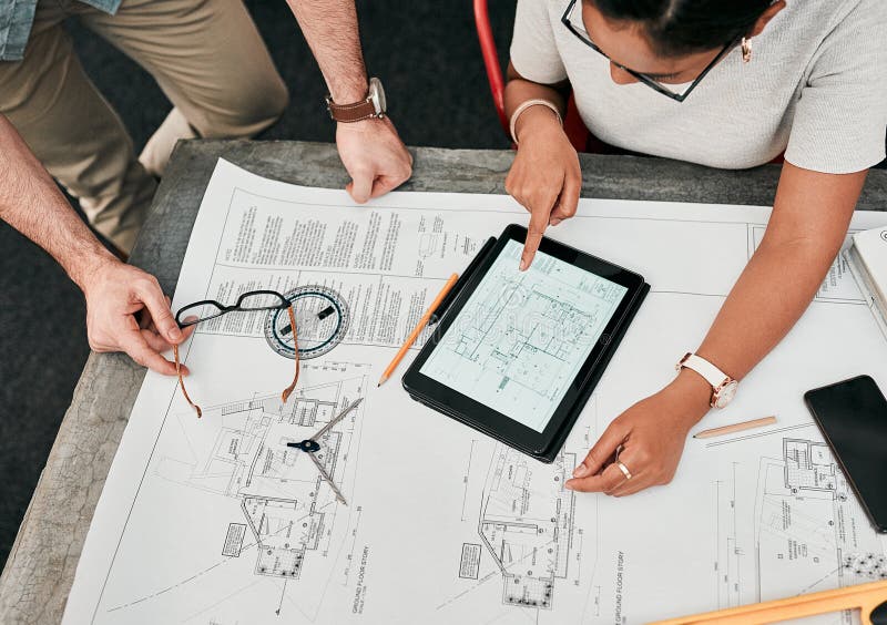 We have everything done except for here... High angle shot of two unrecognizable architects using a digital tablet while royalty free stock photos