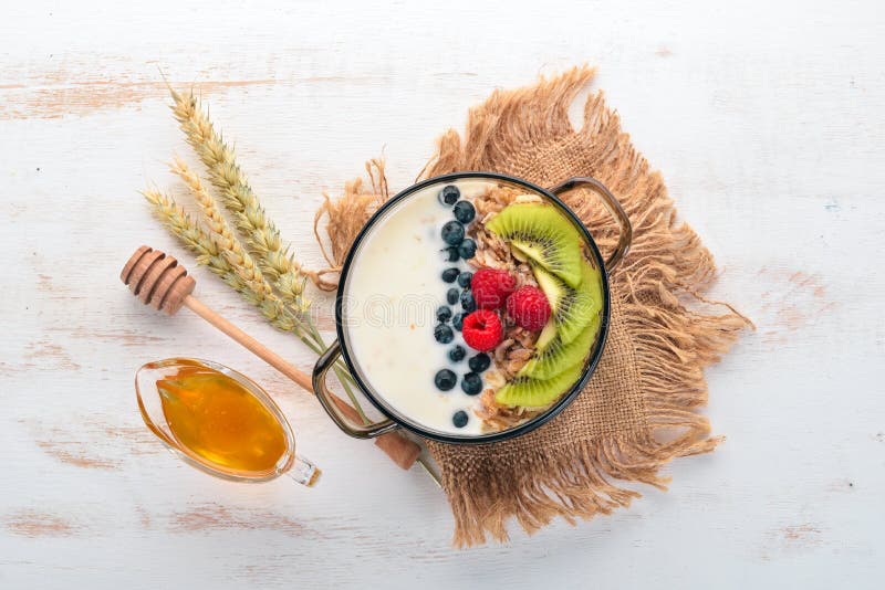 Havermeel met yoghurt en vruchten en bessen Kiwi, bosbessen, frambozen Op een houten achtergrond stock foto Havermeel met yoghurt en vruchten en bessen Kiwi, bosbessen, frambozen Op een houten achtergrond stock foto