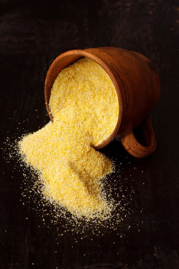 Ceramic cup of polenta spilling onto an old wooden table. Ceramic cup of polenta spilling onto an old wooden table.