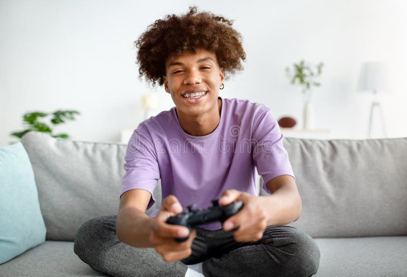 Having Fun at Home. Cheerful Black Teen Guy with Joystick Playing Online  Computer Games, Sitting on Couch Indoors Stock Image - Image of computer,  person: 227478857