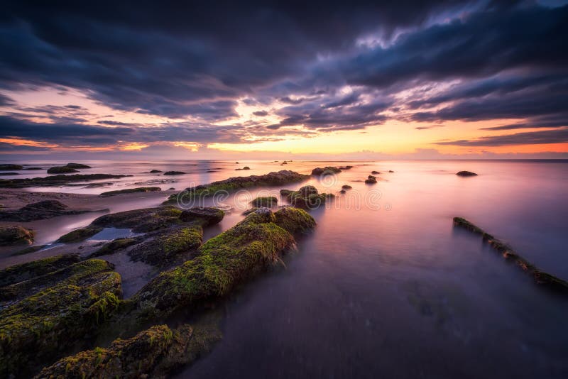 Havssoluppgång på den steniga stranden royaltyfri foto Havssoluppgång på den steniga stranden royaltyfri foto