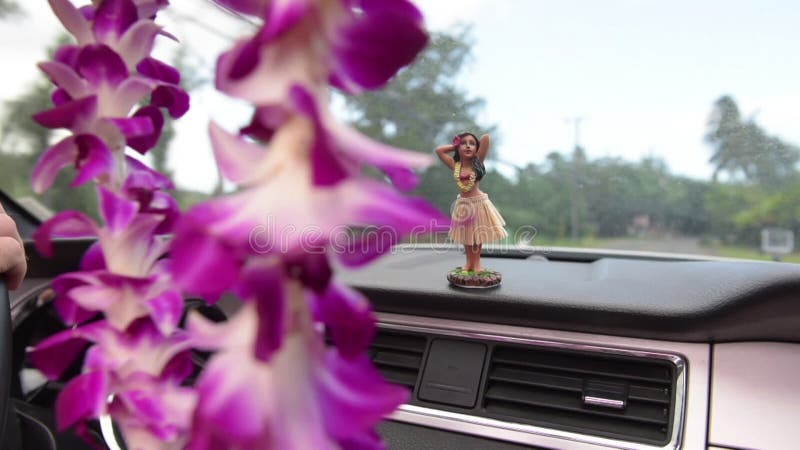 Hawaii travel car - Hula doll dancing on dashboard and lei during road trip on Hawaii