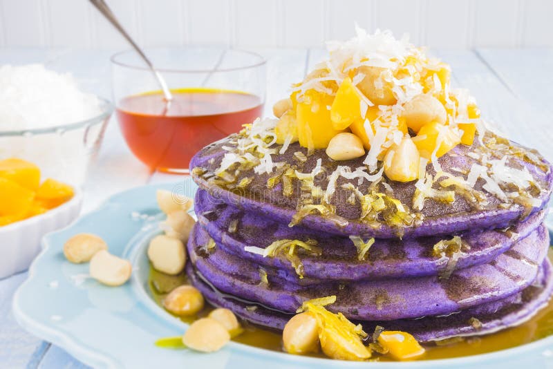 Taro pancakes topped with mango, macadamia nuts, shredded coconut and lilikoi syrup. Taro pancakes topped with mango, macadamia nuts, shredded coconut and lilikoi syrup