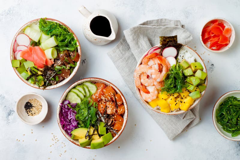 Hawaiian salmon, tuna and shrimp poke bowls with seaweed, avocado, mango, pickled ginger, sesame seeds. stock photos