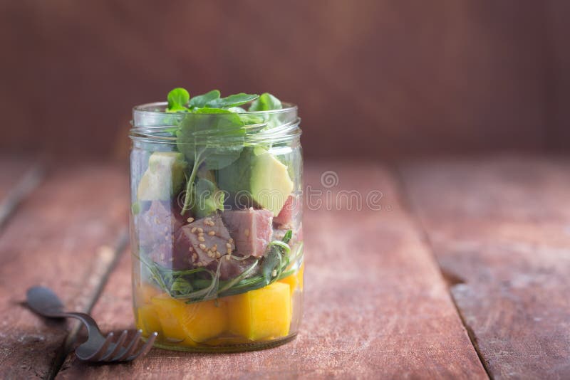 Hawajska potrącenie sałatka z tuńczykiem, avocado i warzywami w słoju na drewnianym nieociosanym tle, obraz stock Hawajska potrącenie sałatka z tuńczykiem, avocado i warzywami w słoju na drewnianym nieociosanym tle, obraz stock