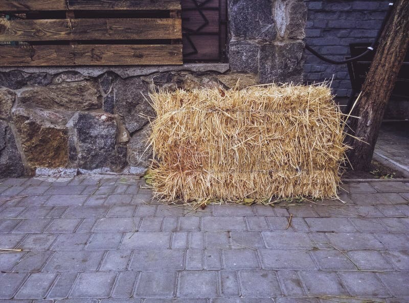 Haystack kłama na miastowych brukowych cegiełkach Wioska w mieście obrazy stock Haystack kłama na miastowych brukowych cegiełkach Wioska w mieście obrazy stock