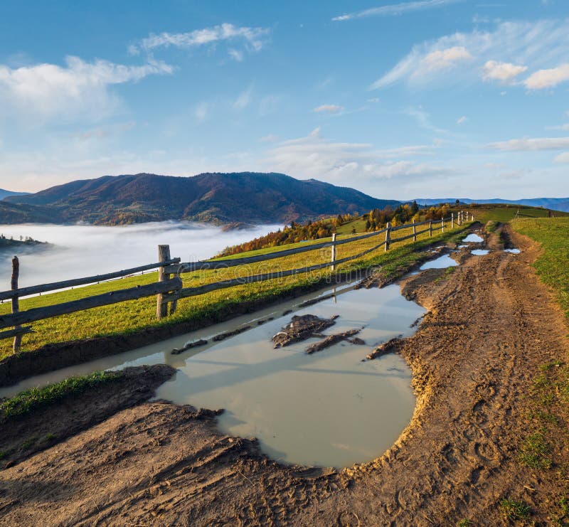Hazy and overcast autumn Carpathian Mountains and dirty countryside path, Ukraine stock images