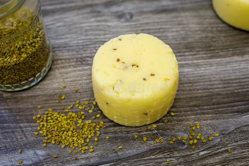 Head of Goat Cheese with Fenugreek Lies on the Table Stock Photo
