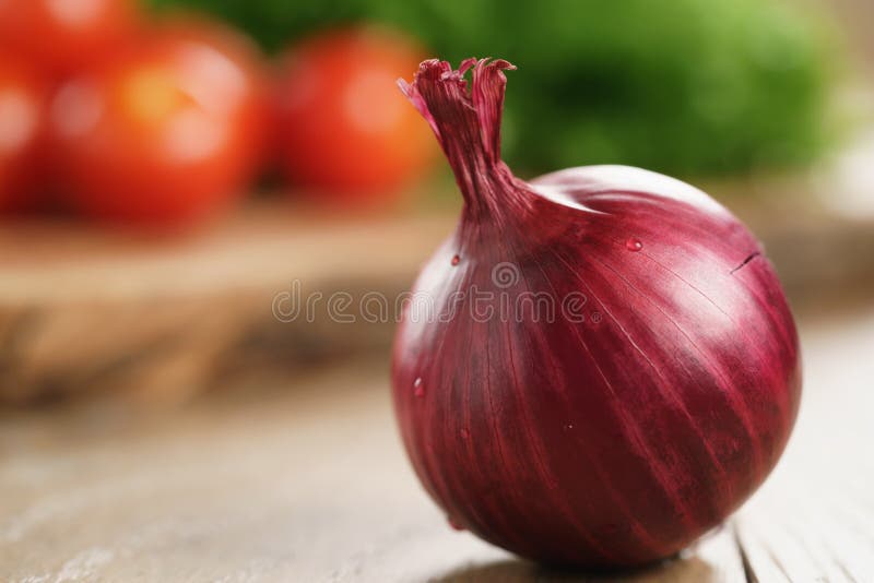 Head of red onion on wooden kitchen table with copy space