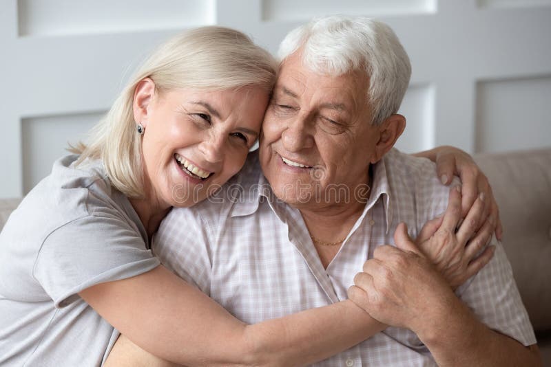 Happy middle aged woman snuggling to smiling older husband. royalty free stock photo Happy middle aged woman snuggling to smiling older husband. royalty free stock photo