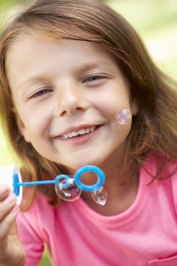 Head and Shoulders Portrait of Girl Blowing Bubbles Stock Photo Image