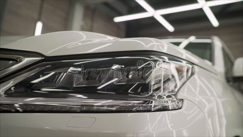 Headlight of an SUV close-up in a car-care center.. SUV Head Light white and close-up grille royalty free stock photo Headlight of an SUV close-up in a car-care center.. SUV Head Light white and close-up grille royalty free stock photo