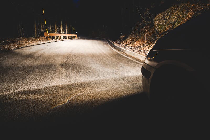 The Headlights of a Car on Mountain Road in the Night Stock Photo