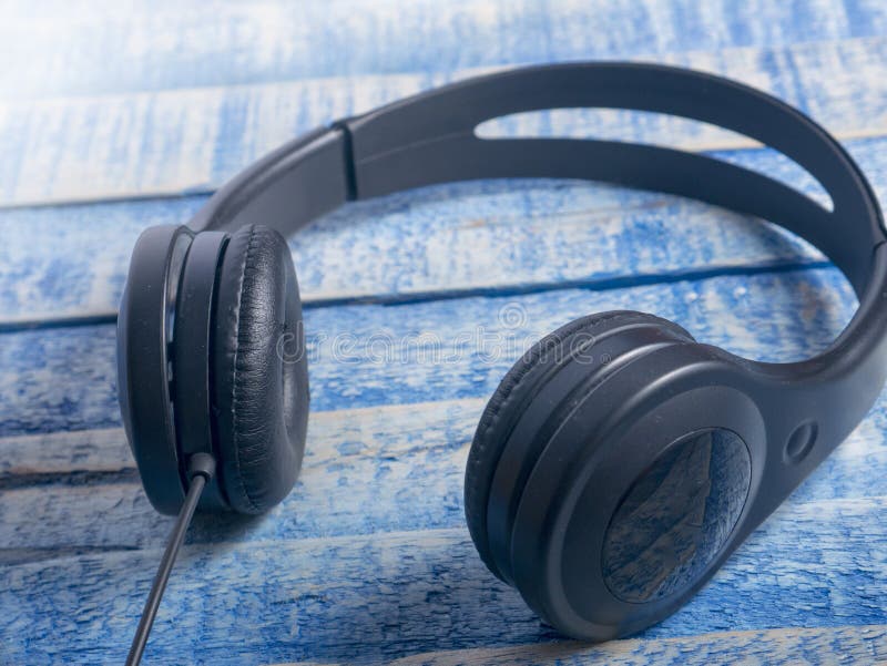 Headphone för musikljud. Headphone Hörlurar på blå träbakgrund Solitt begrepp för musik