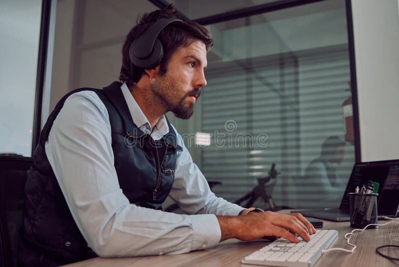 Headphones, programmer keyboard and man typing, coding or programming online at night. Information technology, computer royalty free stock photo