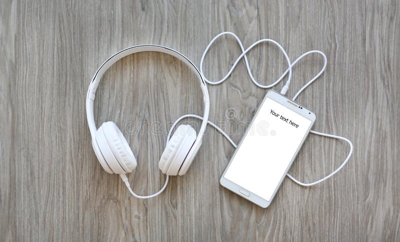 Headphones and smartphone with word `Your text here` on white screen stock photos Headphones and smartphone with word `Your text here` on white screen stock photos