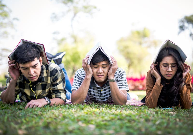 Heads utvändigt skydd för tonåringstudenter där vid hårt begrepp för bokexamenspänning royaltyfri fotografi Heads utvändigt skydd för tonåringstudenter där vid hårt begrepp för bokexamenspänning royaltyfri fotografi