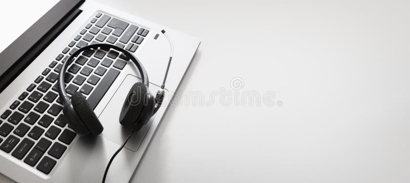 Headset on a laptop computer keyboard. VOIP headset on laptop computer keyboard concept for communication, it support, call center and customer service help desk royalty free stock image Headset on a laptop computer keyboard. VOIP headset on laptop computer keyboard concept for communication, it support, call center and customer service help desk royalty free stock image
