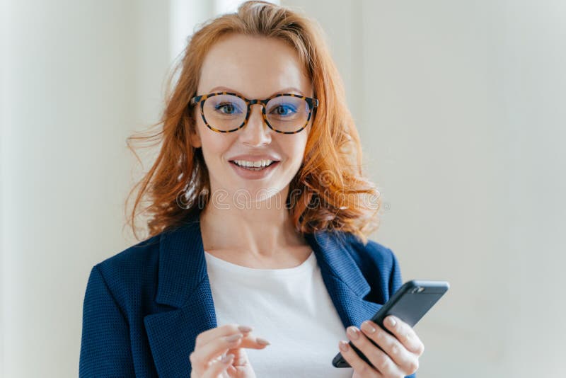Headshot of Female Banker with Pleasant Appearance and Red Hair, Does Banking Online on Cell Phone, Checks Notification on Stock Photo - Image of person, people: 143608324 Headshot of Female Banker with Pleasant Appearance and Red Hair, Does Banking Online on Cell Phone, Checks Notification on Stock Photo - Image of person, people: 143608324