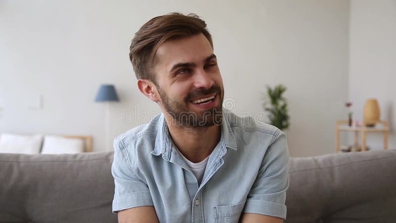 Headshot portrait guy sitting on couch talking looking at camera