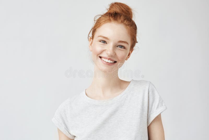 Headshot portret szczęśliwa imbirowa dziewczyna ono uśmiecha się z piegami patrzejący kamerę Biały tło